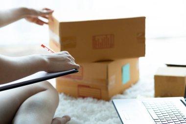 Online alışveriş için dizüstü bilgisayarla çalışan Asyalı kadınlar evde paketleme için kutu, Online alışveriş için Küçük İş Başlat. Alışveriş merkezi iş konsepti.
