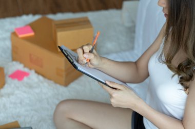 Online alışveriş için dizüstü bilgisayarla çalışan Asyalı kadınlar evde paketleme için kutu, Online alışveriş için Küçük İş Başlat. Alışveriş merkezi iş konsepti.