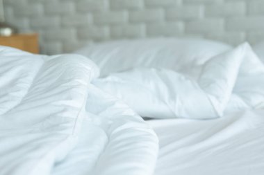 Yatağı beyaz yastıkla, battaniyeyi de sabah yatak odasında doğal ışık ile kirletti.,