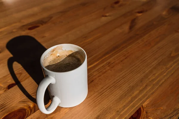 Ahşap bir masada kahve fincanının yan açısı.