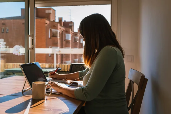 Kadın evden çalışıyor, yandan bakıyor.