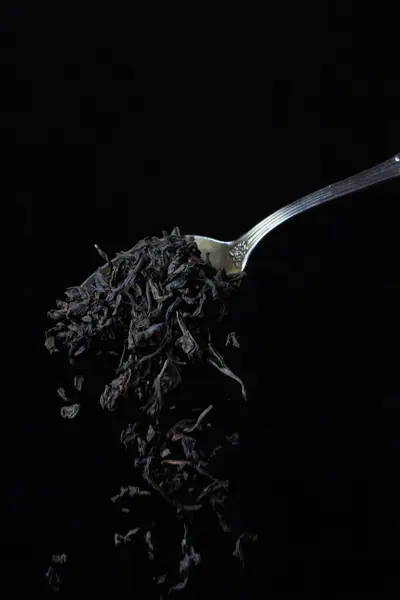 Χαλαρό Τσάι Φύλλο Πέφτει Από Ένα Κουταλάκι Του Γλυκού Μαύρο — Φωτογραφία Αρχείου