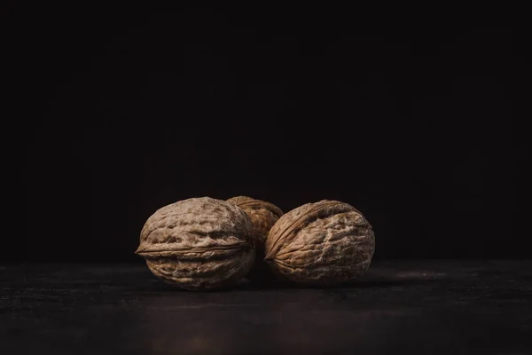 three nuts on a black background