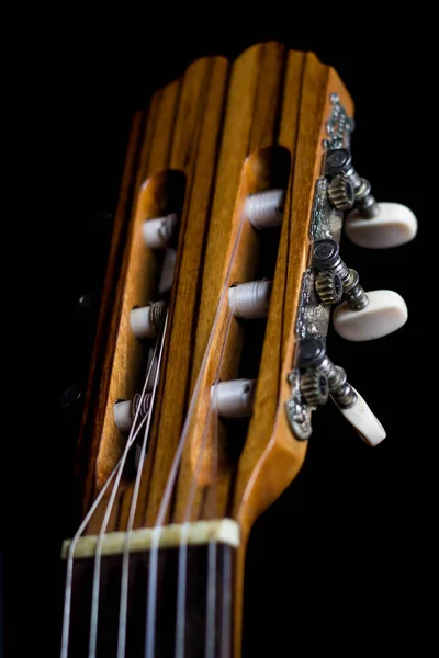guitar neck of a classical guitar on a black background