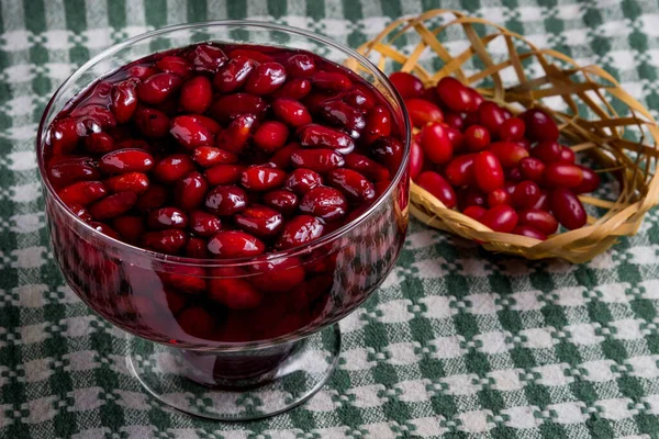 Dogwood reçeli ve yanında hasır sepetin içinde taze bir odun, hepsi ekose havlunun üzerinde.