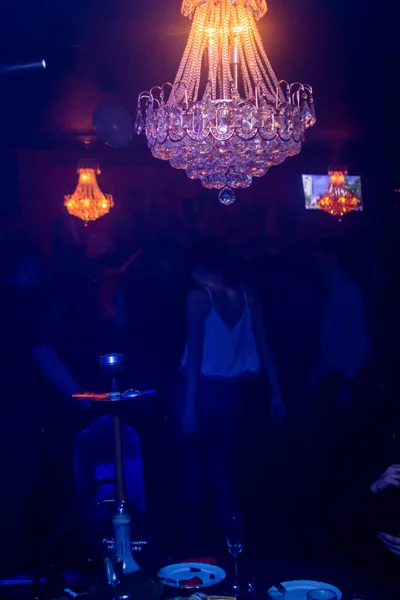 ナイトクラブで踊る 人々はクリスタルシャンデリアの下で踊ります 青の色合いの写真 — ストック写真
