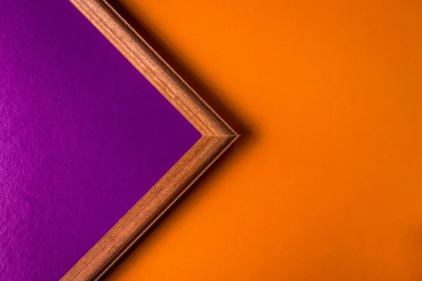 橙色背景上的木制框架 镜框里面是淡紫色的背景 框架占去了一半的空间 空地方作登记 — 图库照片