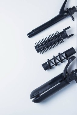 Saç stili yaratmak için aletler. Bir yazıt için arka plan. Kuaför konsepti. Beyaz arkaplanda çeşitli siyah saç stili araçları bulunur