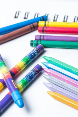 Beyaz arkaplana dağılmış çeşitli renkli kalemler