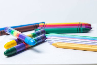 Beyaz arkaplanda çeşitli renkli kalemler var