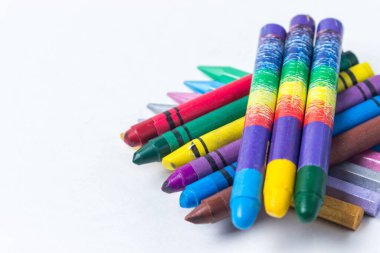 Üç sıra renkli kalem üst üste uzanıyordu. Beyaz arkaplanda fotoğraf.