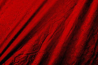 Kumaşın üzerine su damlaları. Kırmızı arka planda su damlaları. Yoğunlaş. Su damlaları arka plan. 