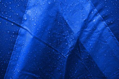 Kumaşın üzerine su damlaları. Su damlaları mavi arkaplanda. Yoğunlaş. Su damlaları arka plan.