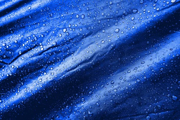 Water drops on the fabric. Water drops on blue background. Condensate. Water drops background.