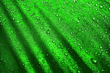 Kumaşın üzerine su damlaları. Yeşil arka planda su damlaları. Yoğunlaş. Su damlaları arka plan. 