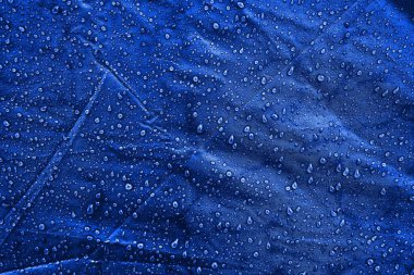 Kumaşın üzerine su damlaları. Su damlaları mavi arkaplanda. Yoğunlaş. Su damlaları arka plan.