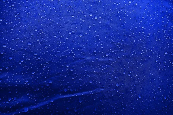 Water drops on the fabric. Water drops on blue background. Condensate. Water drops background.
