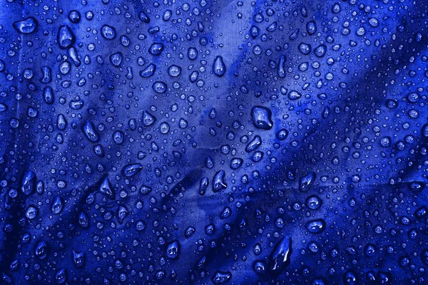 Water drops on the fabric. Water drops on blue background. Condensate. Water drops background.