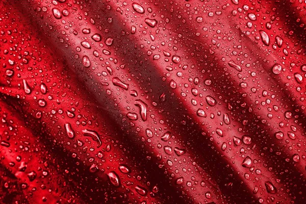 Water drops on the fabric. Water drops on red background. Condensate. Water drops background.