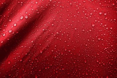 Kumaşın üzerine su damlaları. Kırmızı arka planda su damlaları. Yoğunlaş. Su damlaları arka plan. 