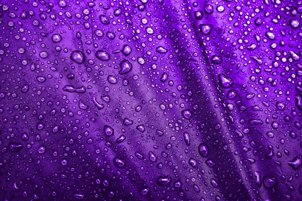 Water drops on fabric. Water drops on purple background. Condensate. Water drops background.