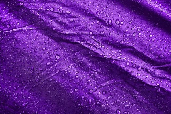 Water drops on fabric. Water drops on purple background. Condensate. Water drops background.