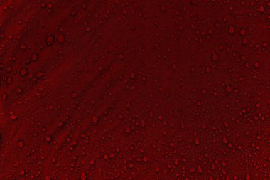 Kumaşın üzerine su damlaları. Kırmızı arka planda su damlaları. Yoğunlaş. Su damlaları arka plan. 