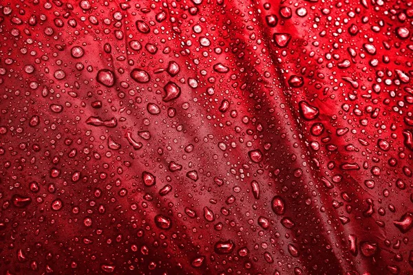 Water drops on fabric. Water drops on red background. Condensate. Water drops background.