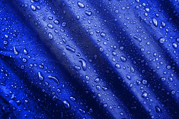 Water drops on fabric. Water drops on blue background. Condensate. Water drops background.