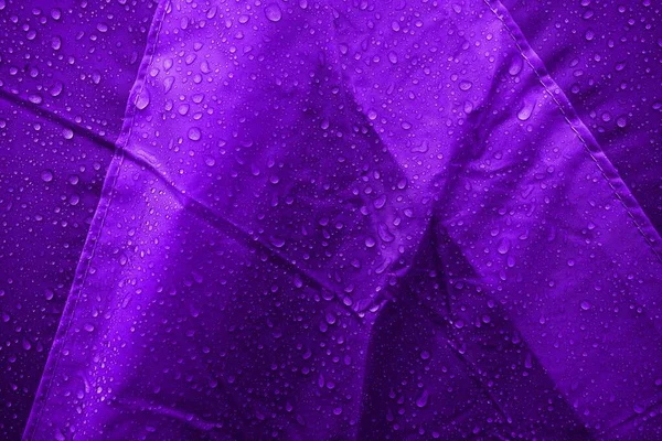 Water drops on fabric. Water drops on purple background. Condensate. Water drops background.