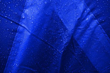 Kumaşın üzerine su damlaları. Arka planda su damlaları var. Yoğunlaş. Su damlaları arka plan.