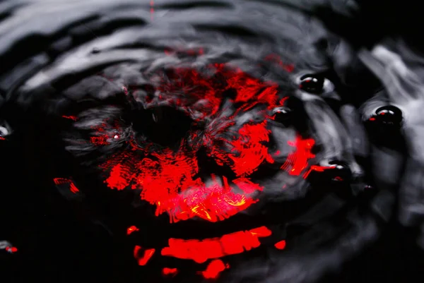背景のような抽象的な水 赤いライトが水面に映る 黒い背景に水のスプラッシュ 意図的な動きのぼかし — ストック写真