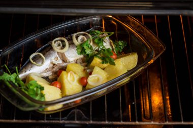 Sebzeli fırında balık. Uskumru fırında. Fırında balık var. fırında sebze. Aşçı balık pişiriyor..