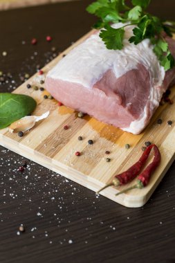 Yeşiller, baharatlar ve et kesme tahtasında. Bir parça domuz eti, biber, sarımsak, tuz. Evde yemek pişir. taze yiyecek