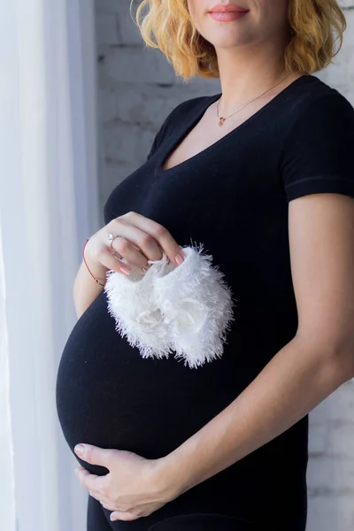 Una Mujer Embarazada Abraza Barriga Sostiene Calcetines Bebé Sus Manos — Foto de Stock