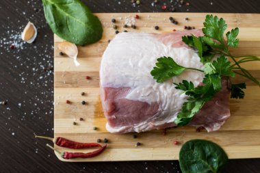 Yeşiller, baharatlar ve et kesme tahtasında. Bir parça domuz eti, biber, sarımsak, tuz. Evde yemek pişir. taze yiyecek