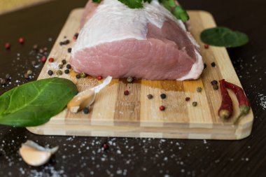 Yeşiller, baharatlar ve et kesme tahtasında. Bir parça domuz eti, biber, sarımsak, tuz. Evde yemek pişir. taze yiyecek