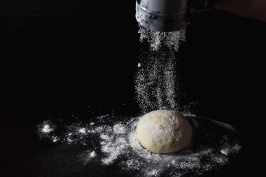 dondurucu hareket. Şef bir kase hamura un serpiyor. Pizza hamuru masada yatıyor. İtalyan pizzası pişirmek. İtalyan restoranı.