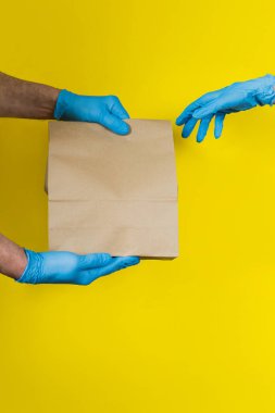 İnternetten alışveriş. Satın alma teslimatı. Mavi eldivenli kurye siparişi müşteriye verir..