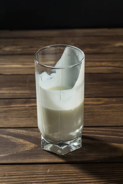 Een Half Vol Glas Melk Ligt Tafel Verticale Foto — Stockfoto