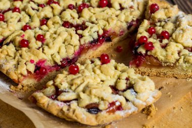 Lezzetli kahvaltı. Aşçı pastaya şeker serpiyor. Tahtada böğürtlenli ev yapımı rendelenmiş turta. Büyük dilim pasta..