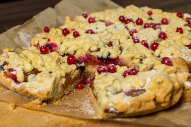 Lezzetli kahvaltı. Aşçı pastaya şeker serpiyor. Tahtada böğürtlenli ev yapımı rendelenmiş turta. Büyük dilim pasta..