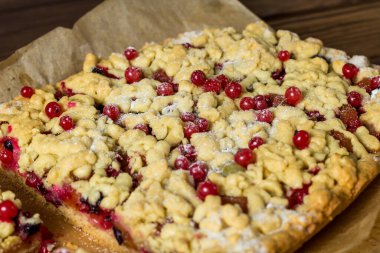 Lezzetli bir kahvaltı. Aşçı pastaya şeker serpiyor. Tahtada böğürtlenli ev yapımı rendelenmiş turta. Büyük bir dilim pasta. Hibiscus şeffaf bir bardakta içer..