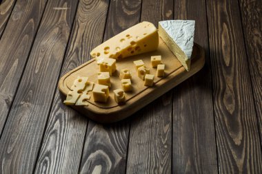 Eski siyah ahşap bir masada peynir tadı. Şarap ve romantizm için yemek, peynir lezzetleri. Menü tasarımı yatay. Yukarıdan görüntüle.