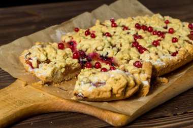 Lezzetli bir kahvaltı. Tahtada böğürtlenli ev yapımı rendelenmiş turta. Büyük bir dilim pasta. Hibiscus şeffaf bir bardakta içer. Kırmızı frenk üzümü, siyah frenk üzümü, bektaşi üzümü..