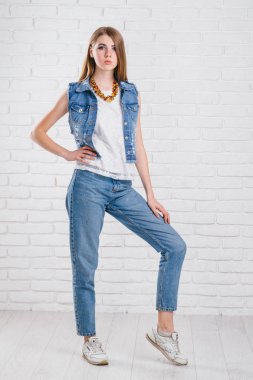 uzun saç poz ile bir modeldir. Kot pantolon, deri ceket.