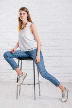 uzun saç poz ile bir modeldir. Kot pantolon, deri ceket.