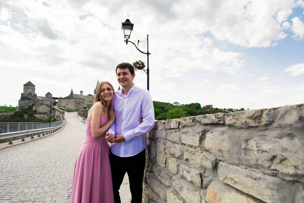 Romántico hombre y mujer pareja en el puente con el antiguo castillo en el fondo —  Fotos de Stock