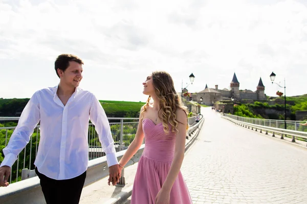 Romántico hombre y mujer pareja en el puente con el antiguo castillo en el fondo —  Fotos de Stock