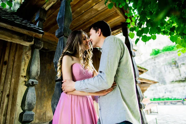 Pareja enamorada parada cerca de casa. pared de madera rústica —  Fotos de Stock